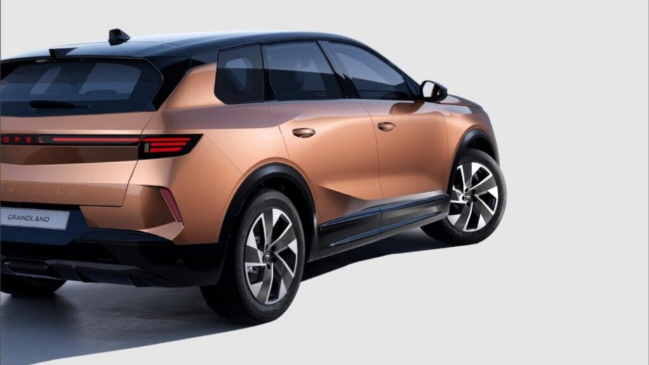 Opel Grandland SUV in Bronze-Metallic, Heck-Seitenansicht mit LED-Lichtleiste und Leichtmetallfelgen vor hellem Studiohintergrund