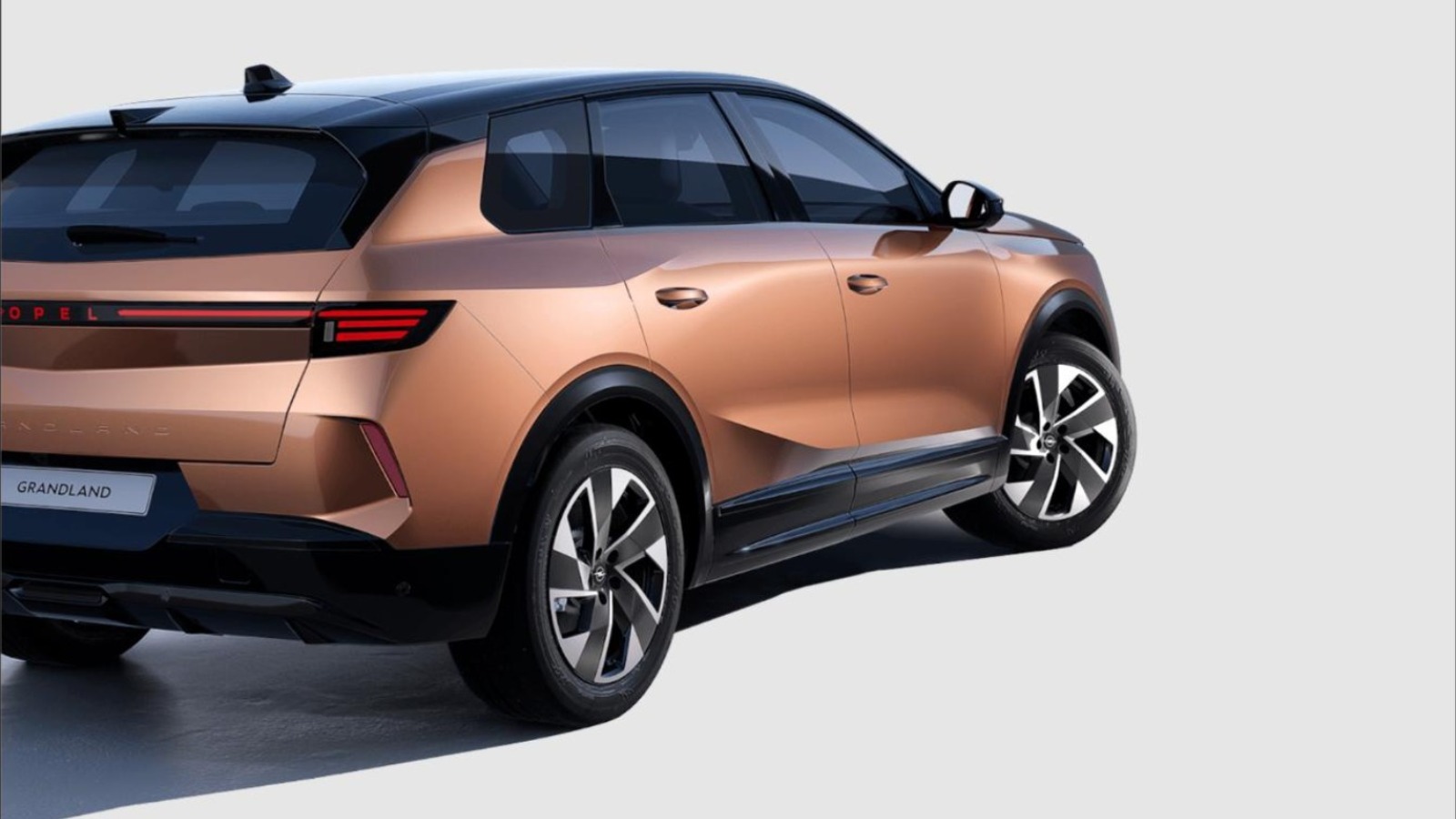 Opel Grandland SUV in Bronze-Metallic, Heck-Seitenansicht mit LED-Lichtleiste und Leichtmetallfelgen vor hellem Studiohintergrund